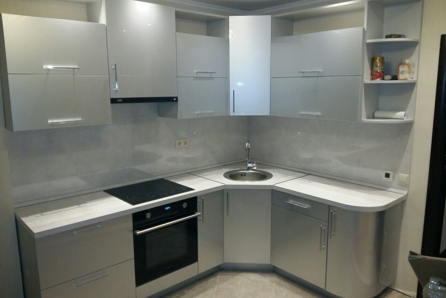 Угловая маленькая кухня с металлической техникой