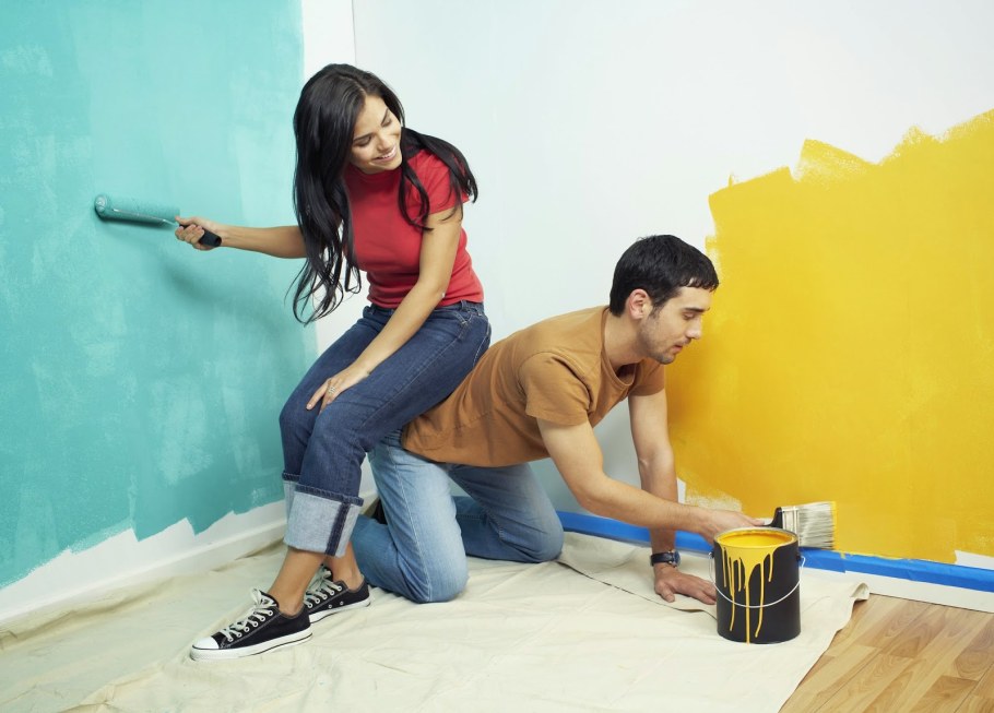 Человек красит стену