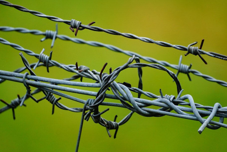 Забор с колючей проволокой на границе