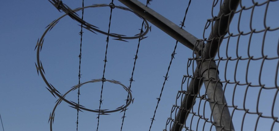 Высокий забор с колючей проволокой