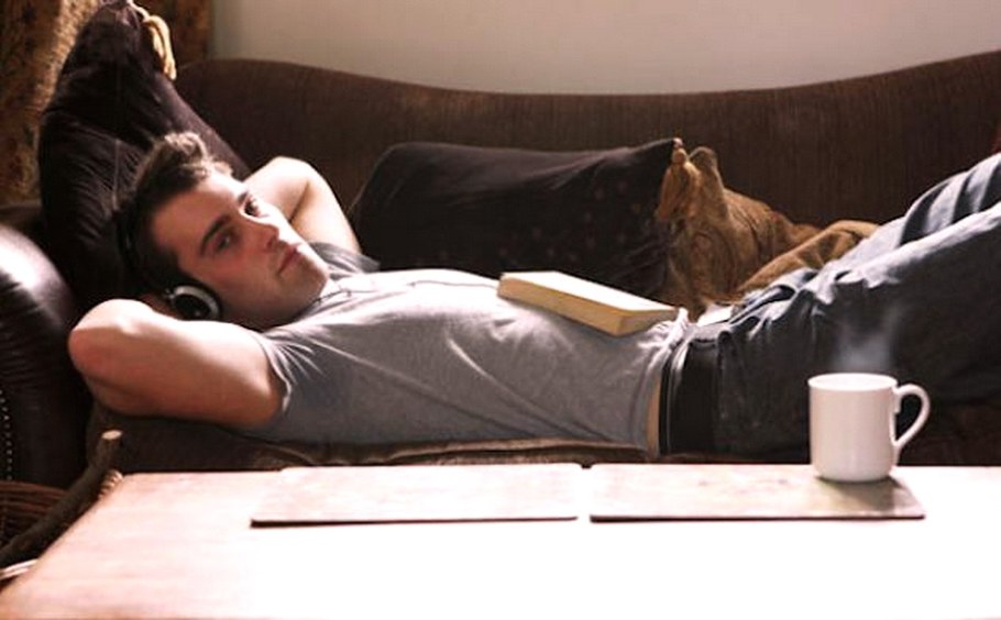 Парениьлежит на диване