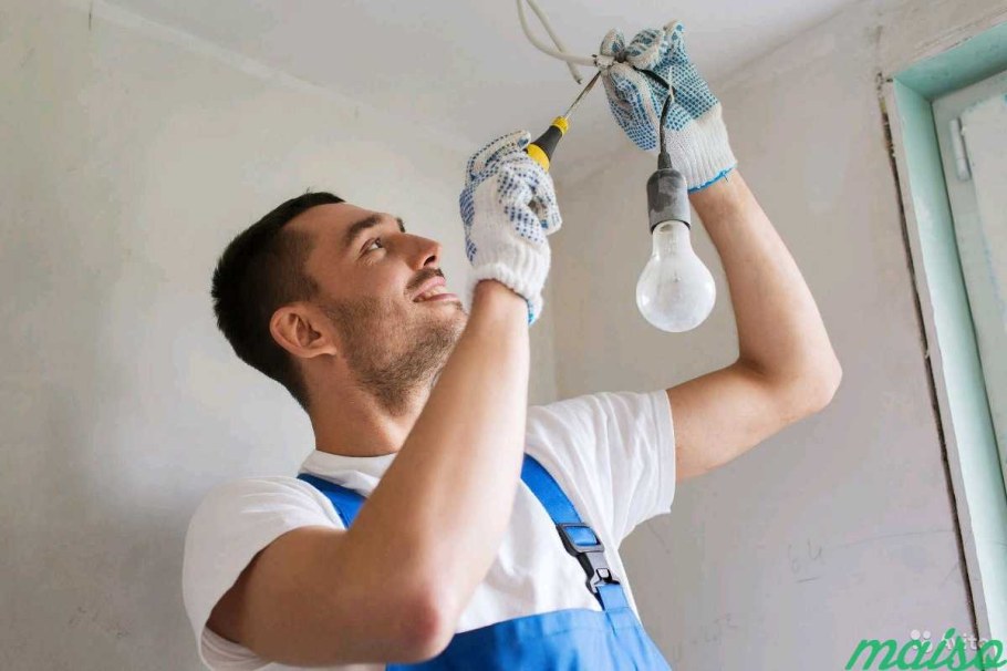 Электрик вкручивает лампочку