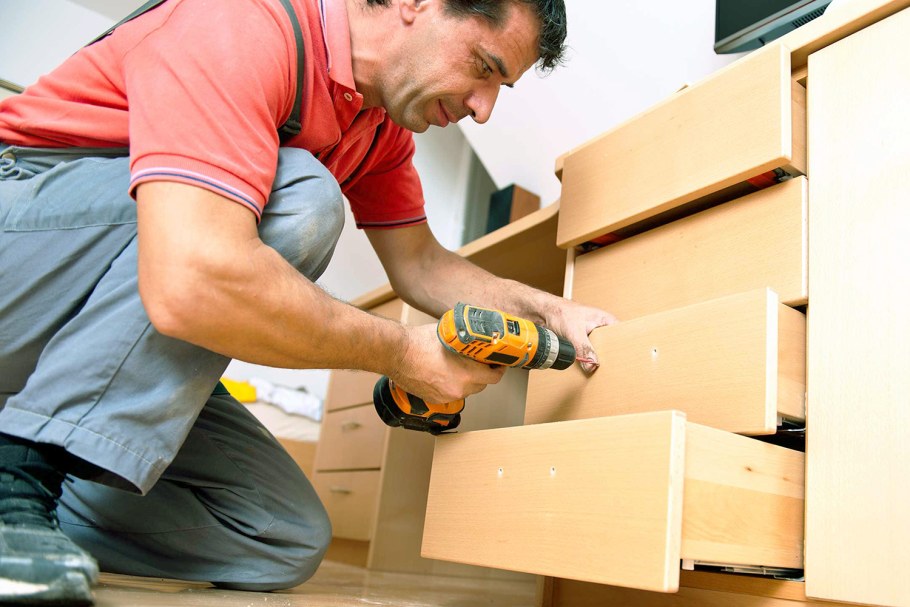 Мужчина собирает кухню