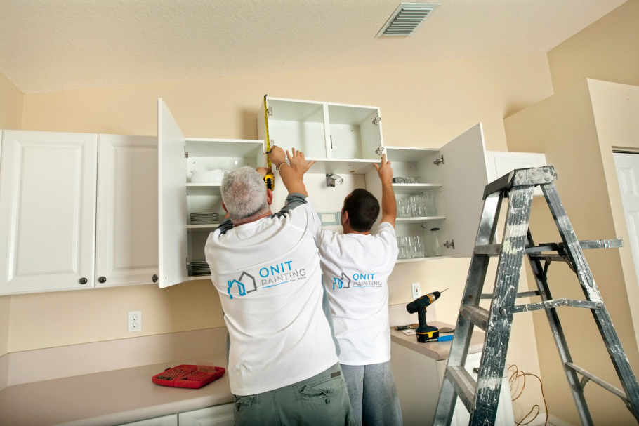 Рабочий собирает кухню