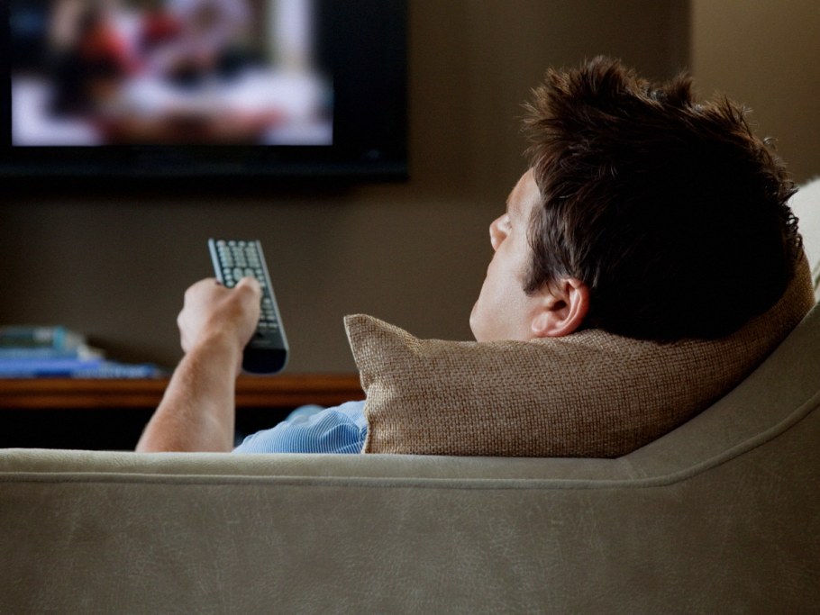 Человек лежит на кровати с телефоном