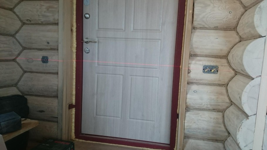 Входная дверь в деревянном доме из бревна