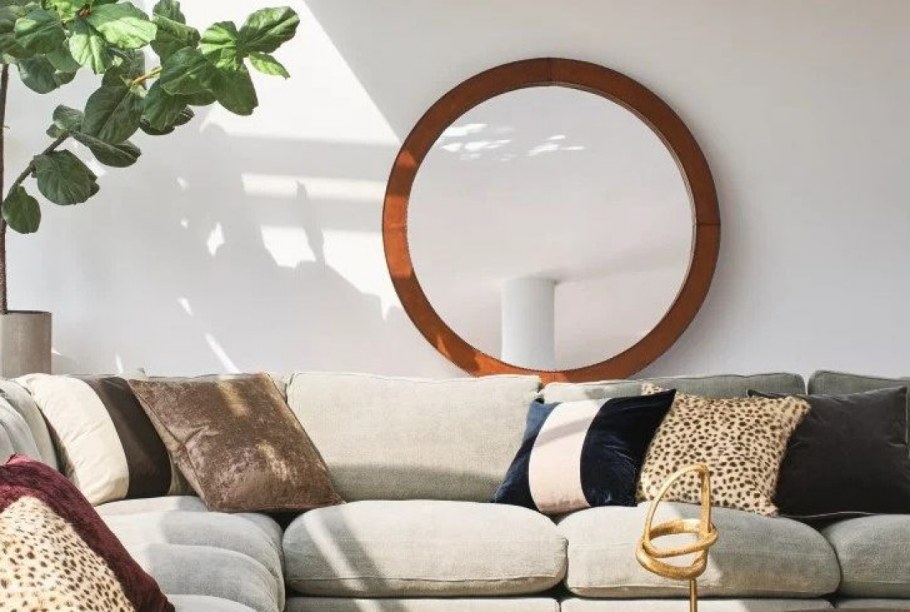 Зеркало солнце над диваном в гостиной