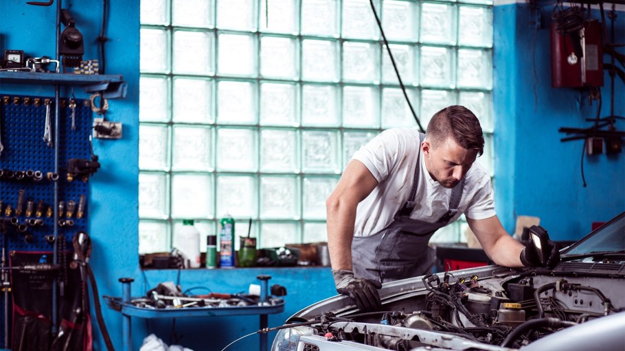 Автомеханик чинит машину