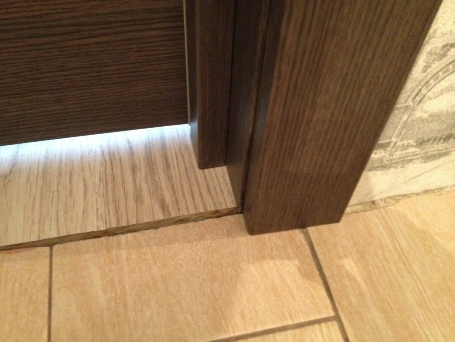 Стык плитки и ламината под дверью