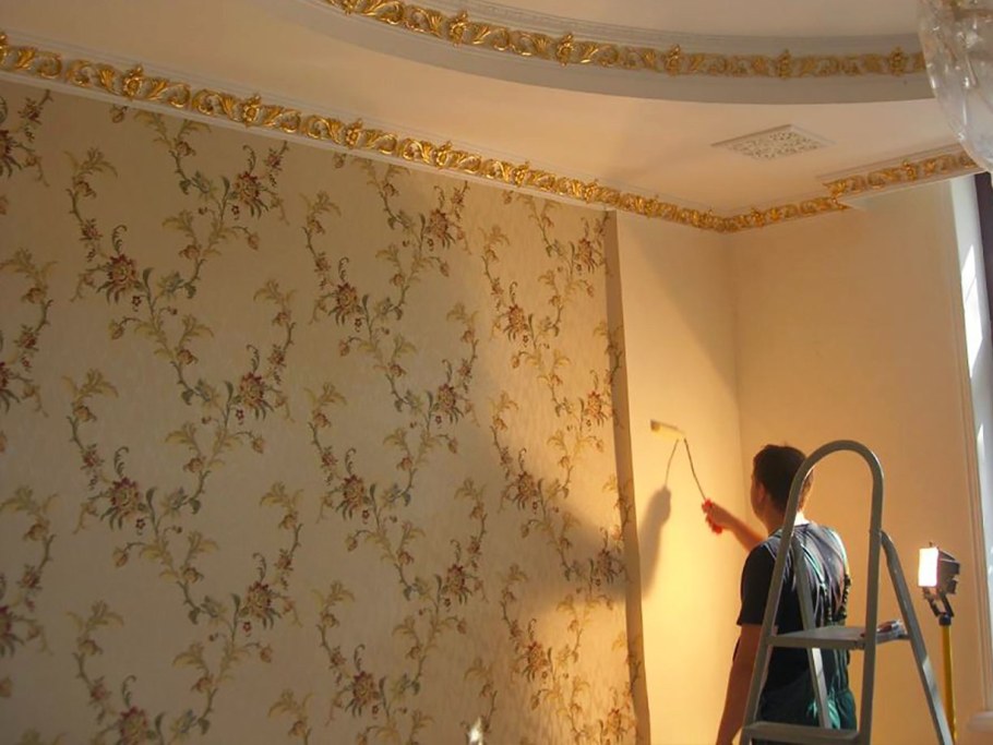 Человек клеит обои