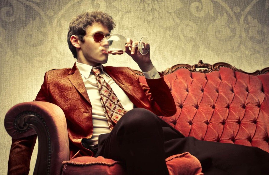 Мужчина в кресле с бокалом