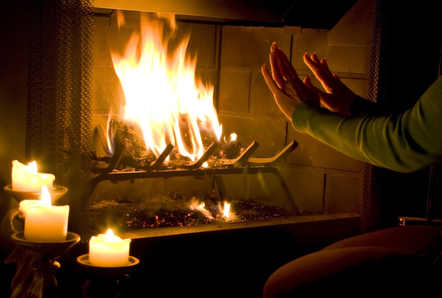 Человек греется у камина