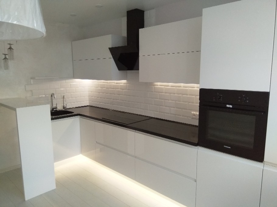 Белая глянцевая кухня с черной столешницей