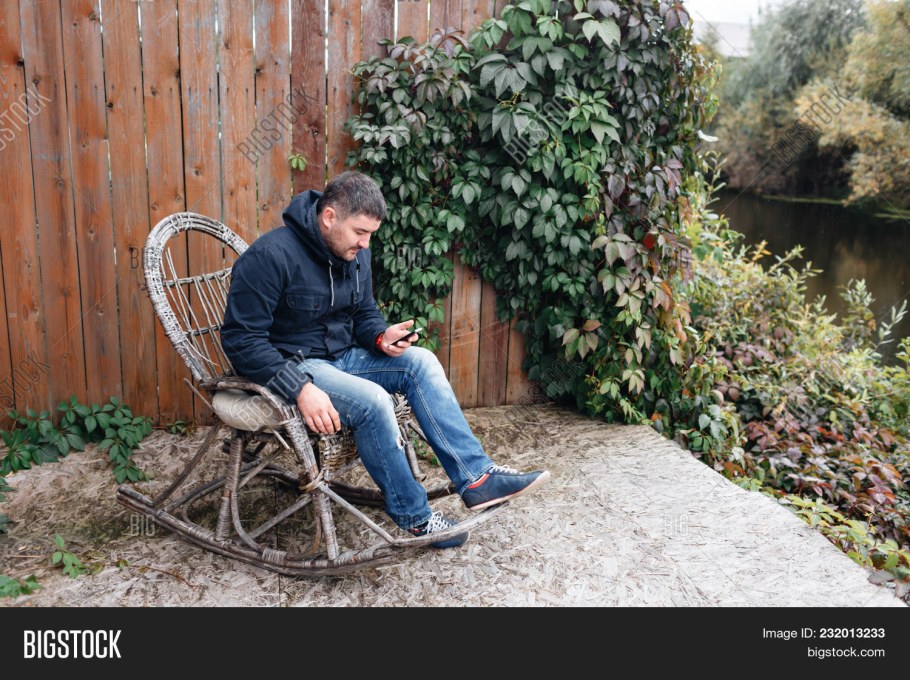Человек в кресле в саду