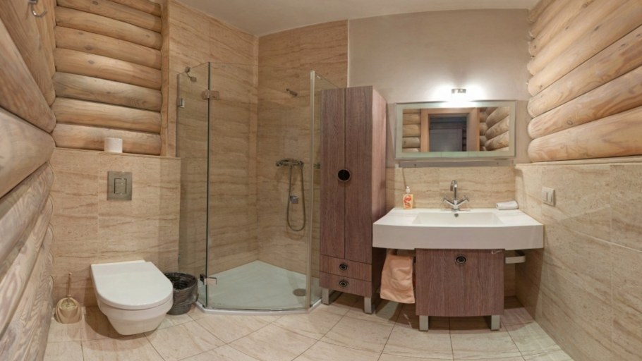 Интерьер ванной комнаты с душевой кабиной в срубовом доме