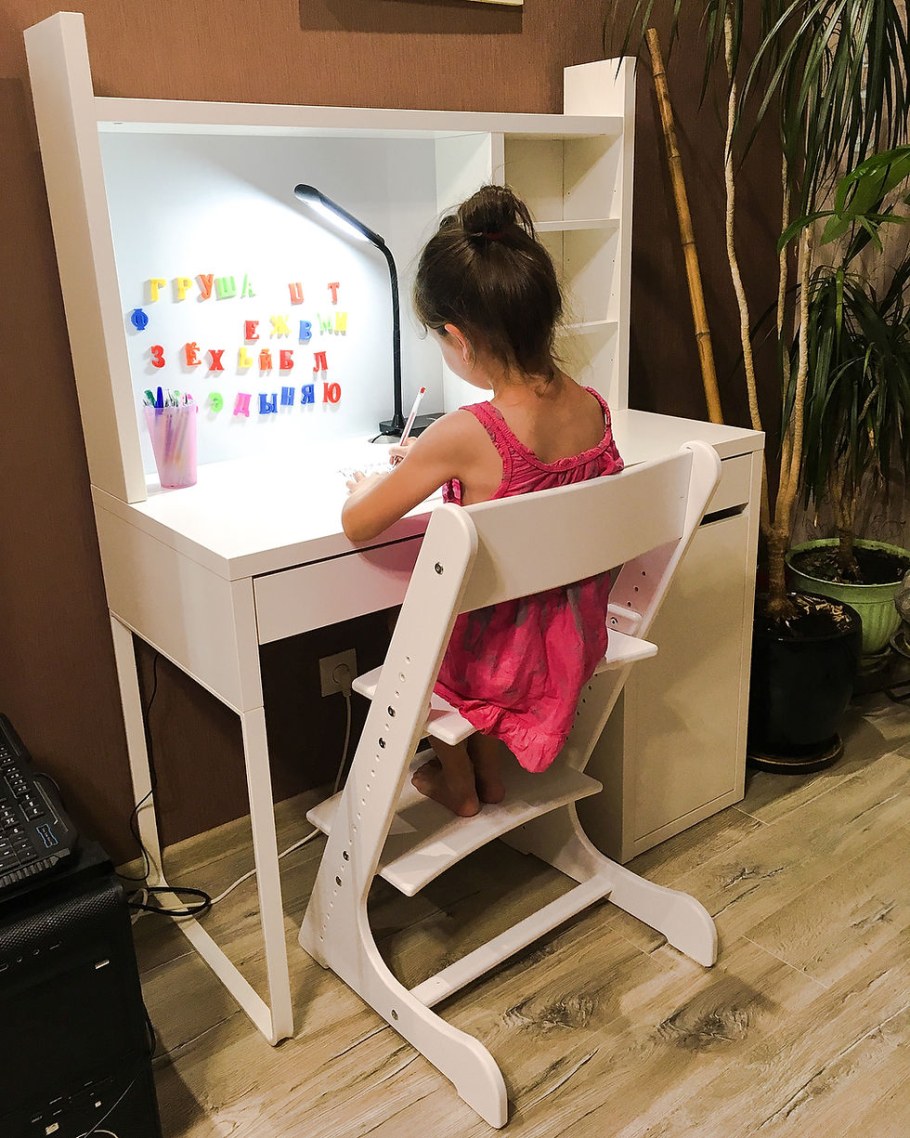 Дети на растущем стуле за столом