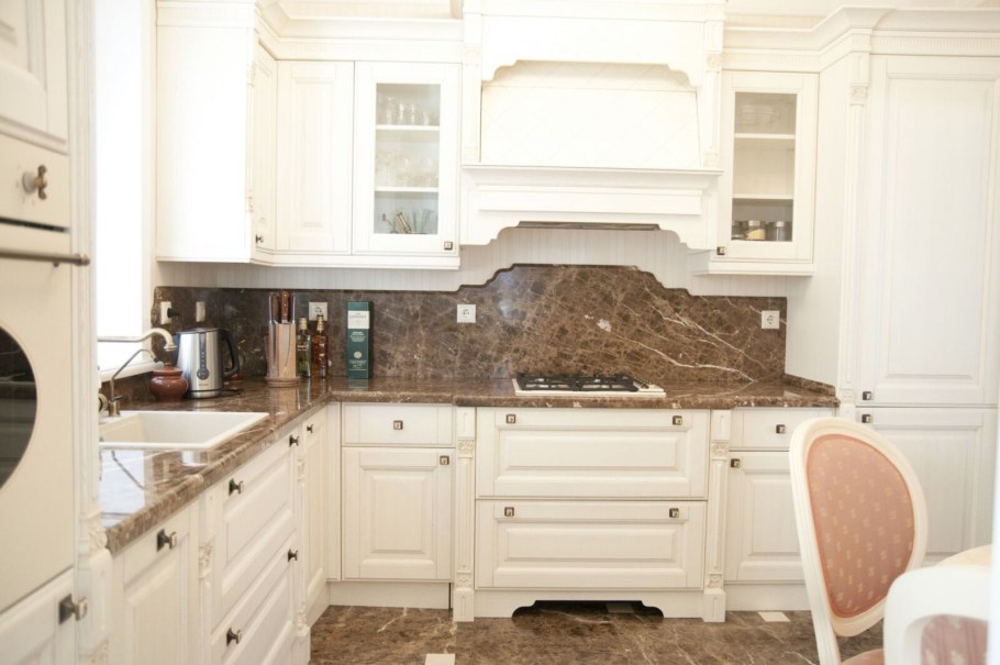 Белая кухня с мраморным фартуком и столешницей беж