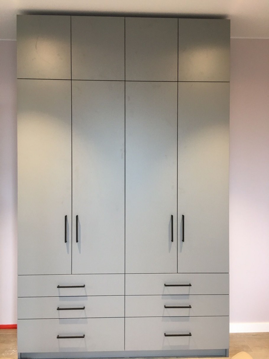 Серый шкаф с черными ручками