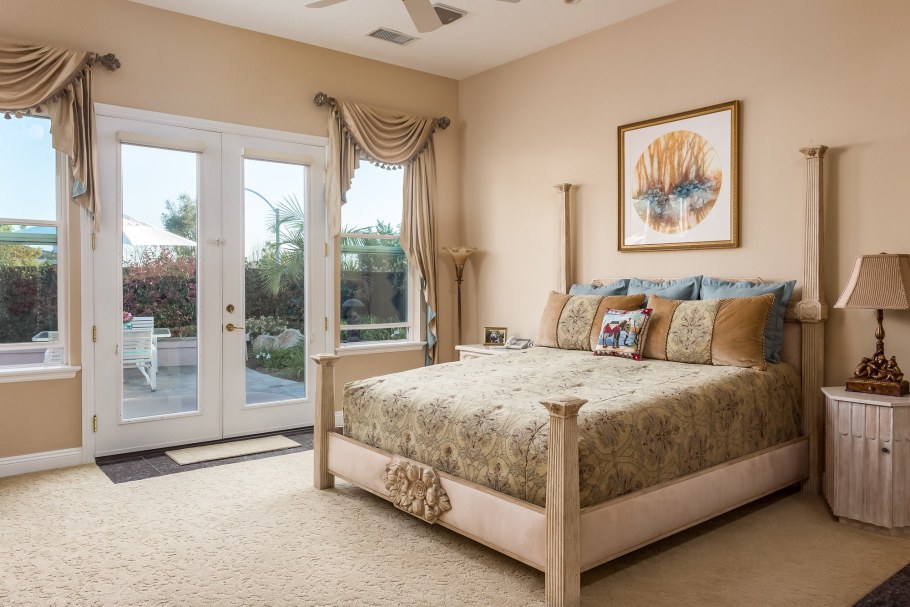 Кровать у окна в спальне