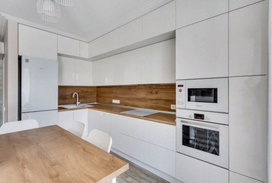 Белая угловая кухня с деревянной столешницей