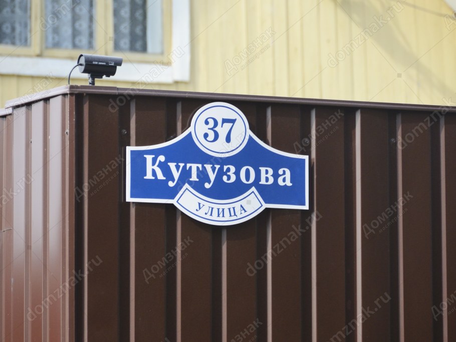 Коричневая адресная табличка на коричневом заборе