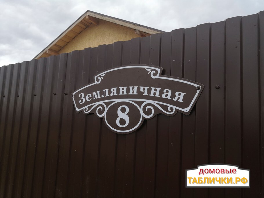 Коричневая адресная табличка на коричневом заборе