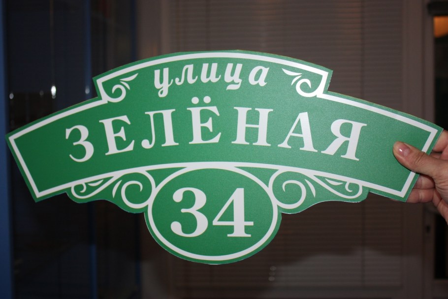 Адресная табличка на зеленом заборе