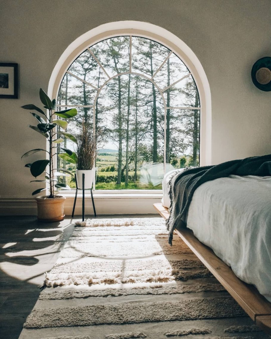 Уютная темная спальня с арочным окном