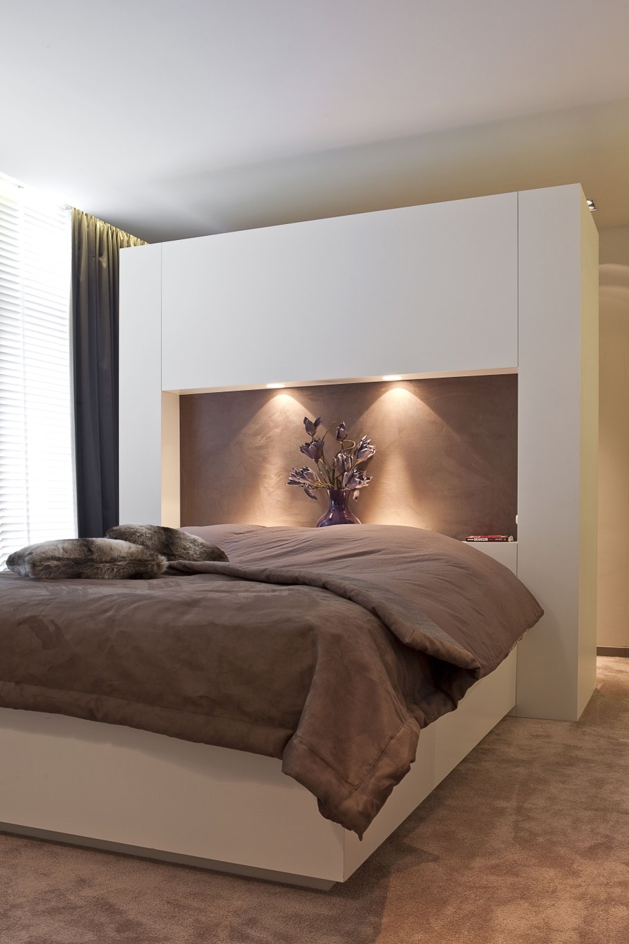 Гардеробная за спинкой кровати в спальне