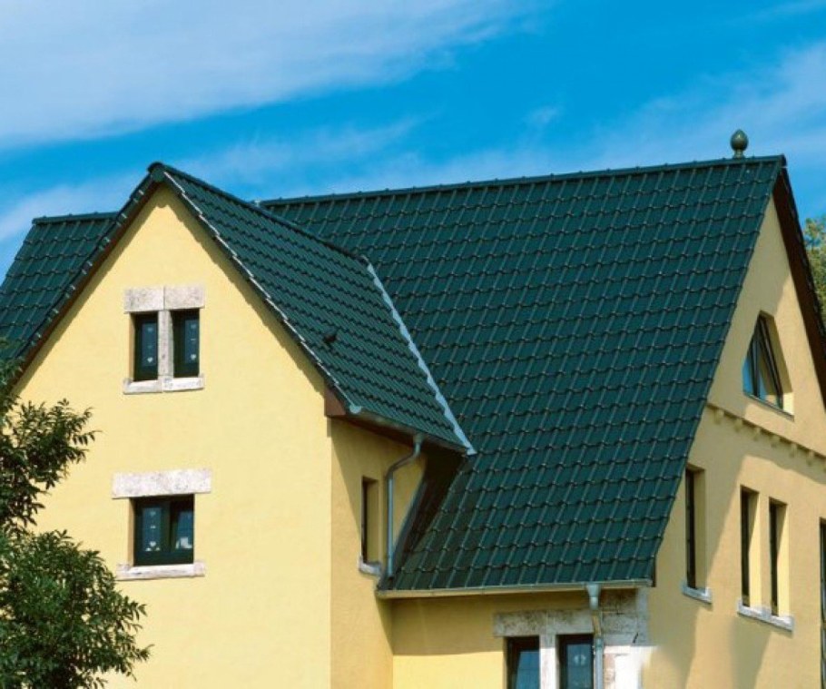 Желтый фасад дома с зеленой крышей