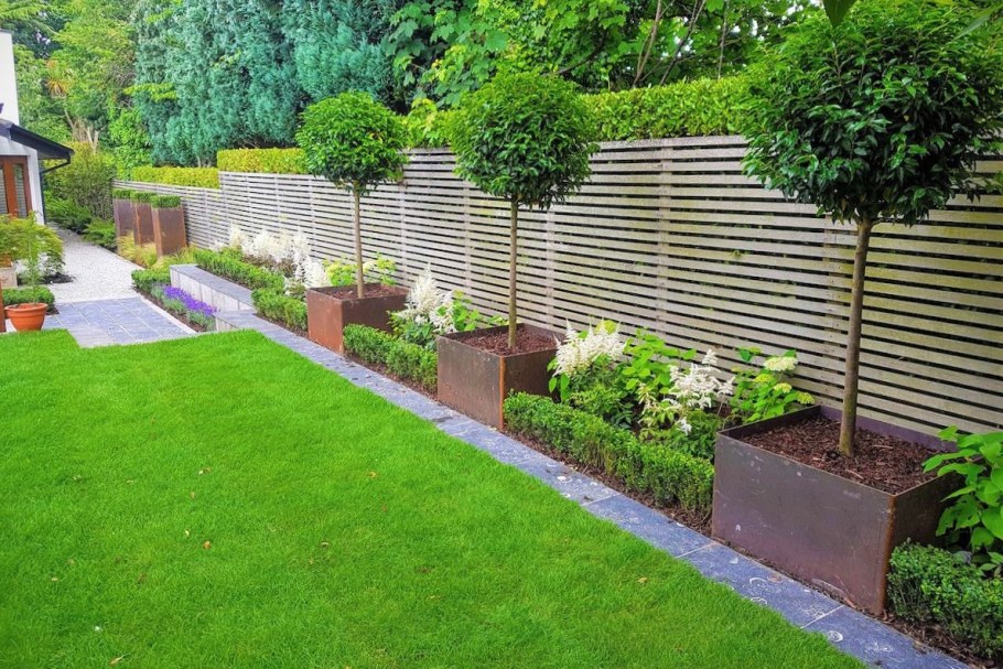 Узкий цветник вдоль забора