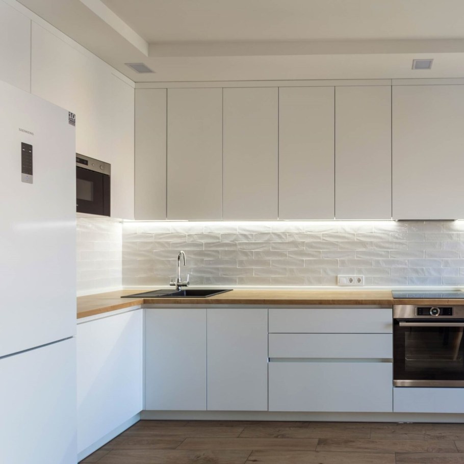 Белая кухня со столешницей под дерево