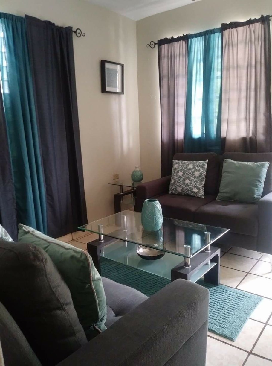 Коричневый диван и бирюзовые шторы