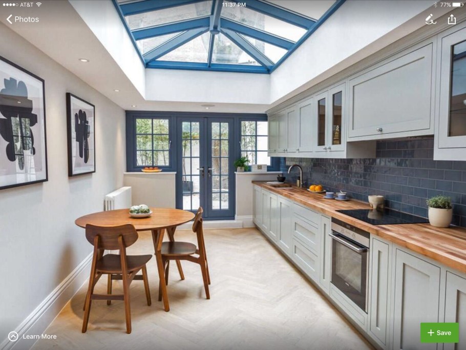 Белая кухня с деревянной столешницей в интерьере