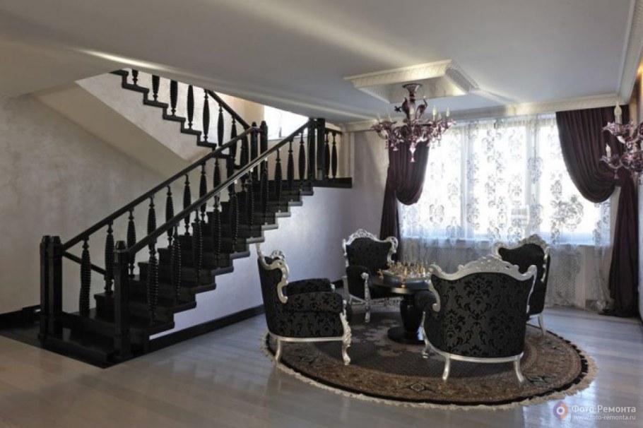 Интерьер гостиной в частном доме с лестницей на второй