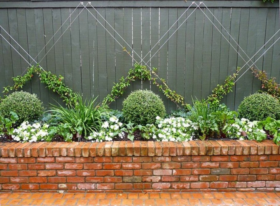 Клумба из камней вдоль забора