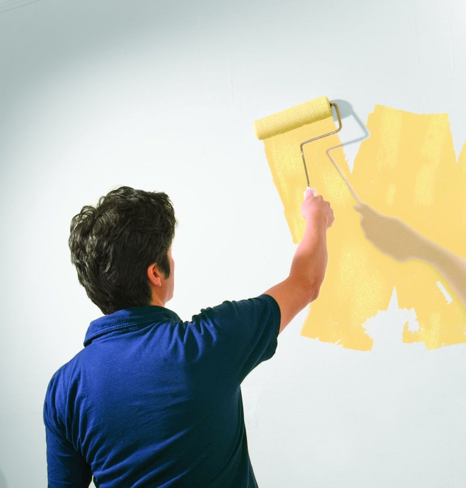 Маляр красит стену