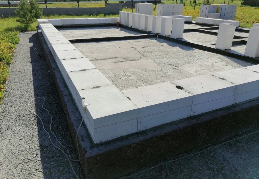 Укладка первого ряда блоков на фундамент