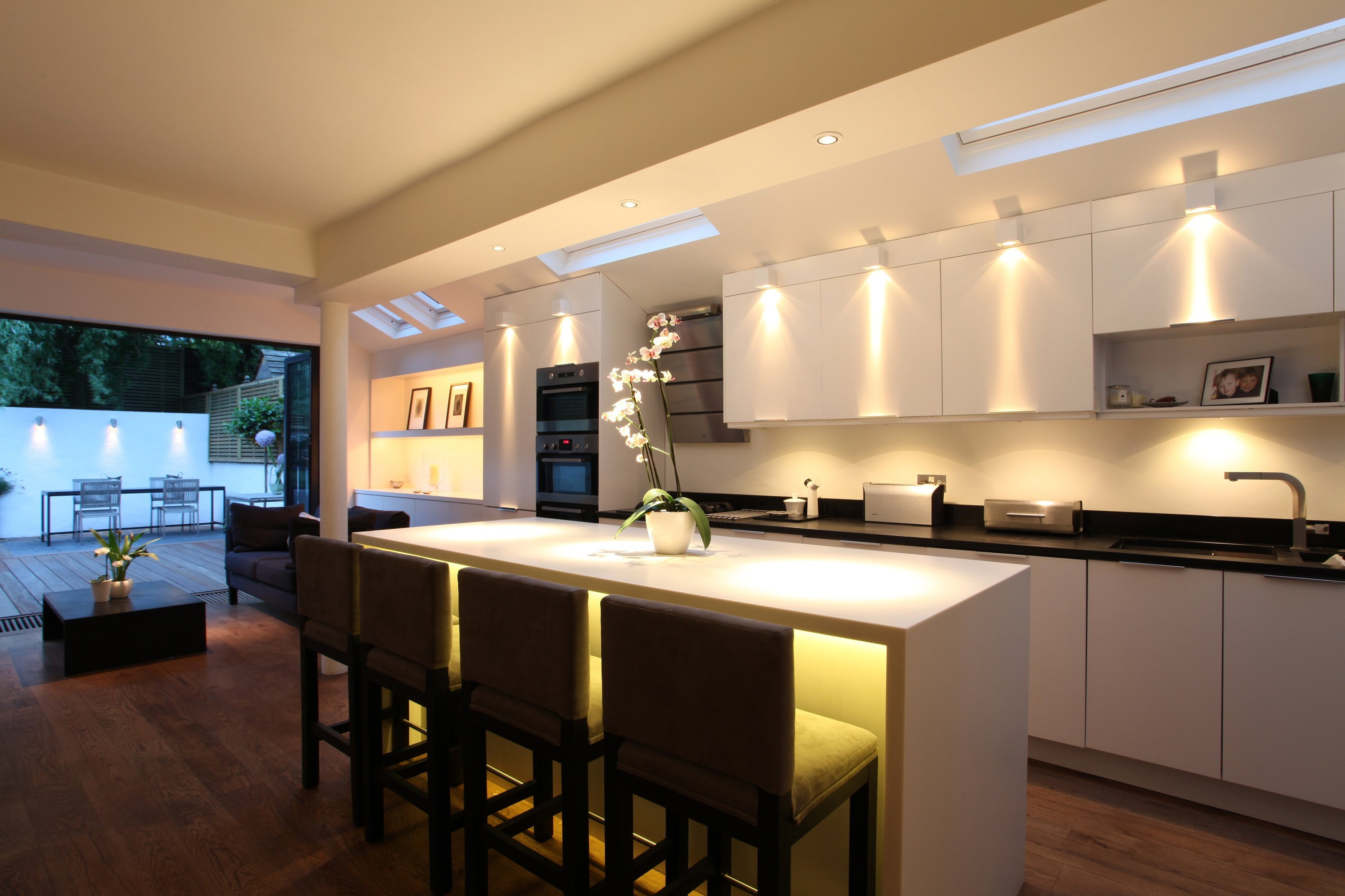 Проектирование освещения теплый свет. Освещение на кухне. Дизайнерское освещение кухни. Современная кухня с подсветкой. Освещение кухонной зоны.
