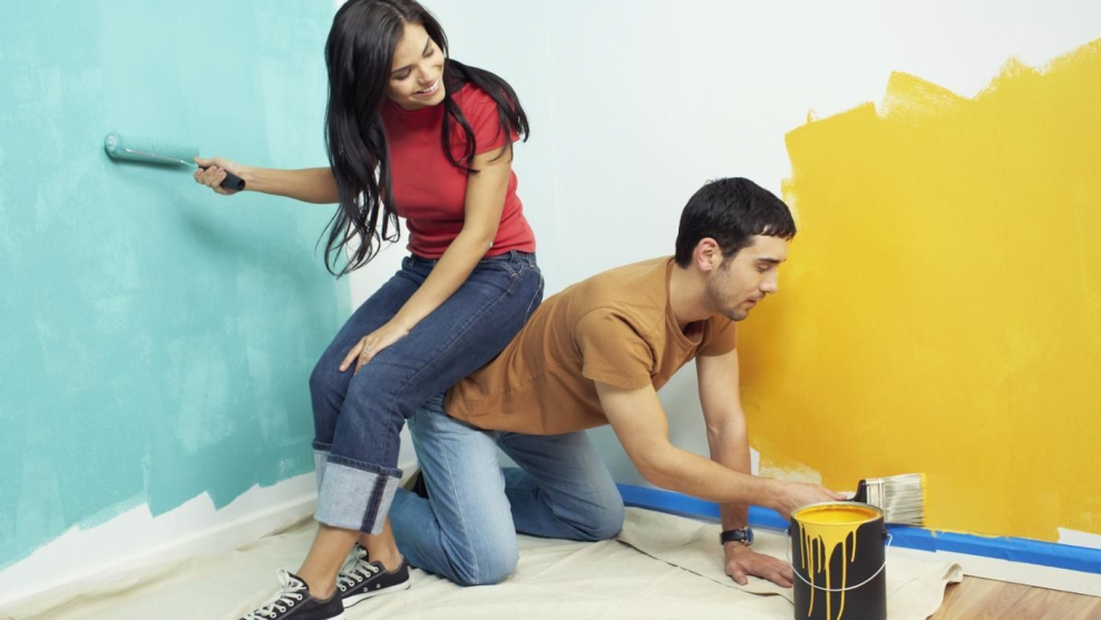 Мужчина красит стену