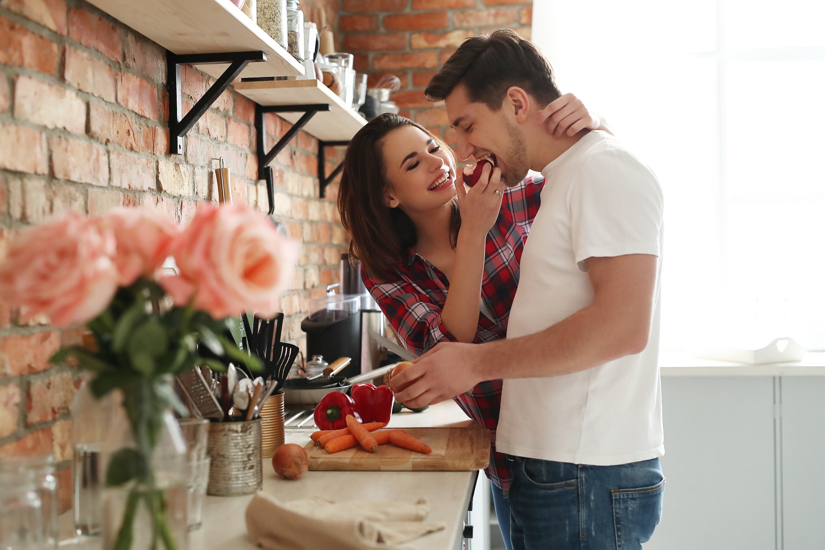 Парень заботится о девушке. Влюбленные на кухне. Романтические отношения. Счастливые романтические отношения. Мужчина и женщина на кухне.