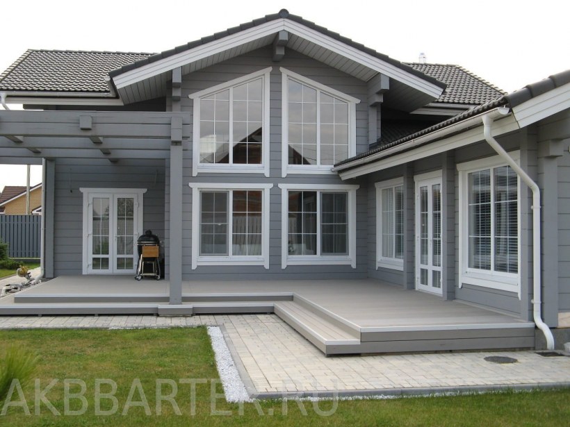 Деревянный дом серого цвета с белыми окнами