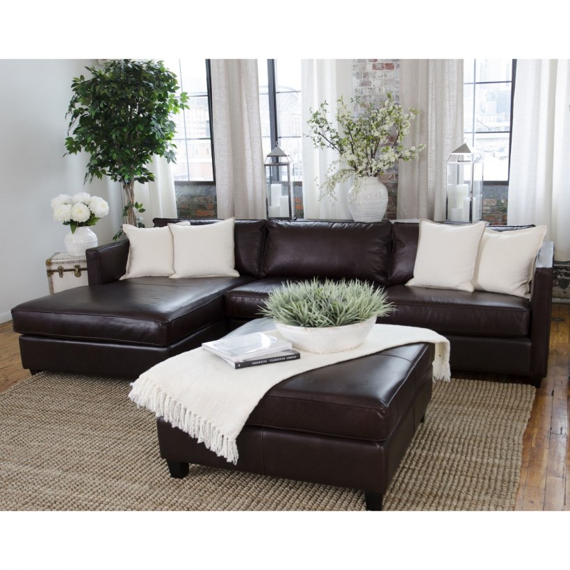 Коричневый диван с белыми подушками