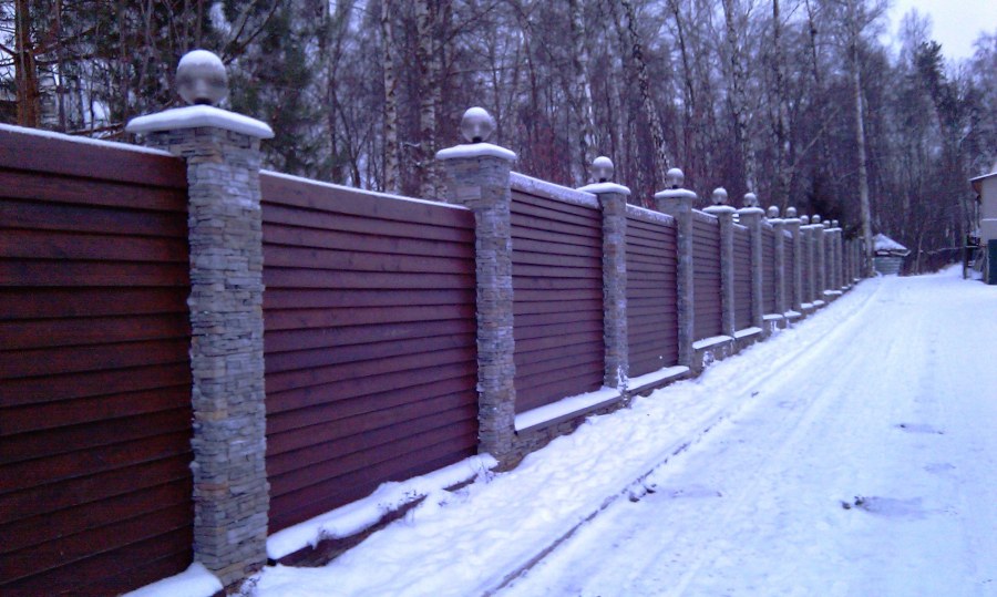 Деревянный забор с каменными столбами