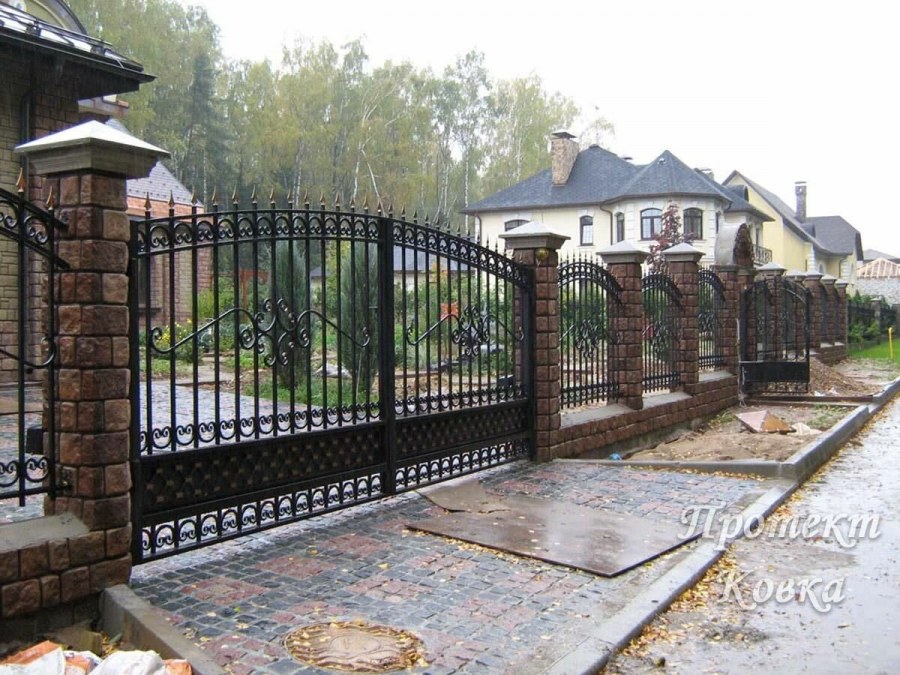 Кованый забор с кирпичными столбами