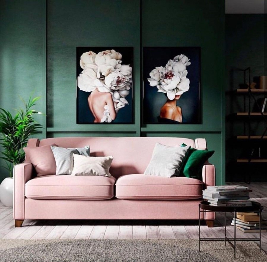 Зеленый диван на фоне розовой стены