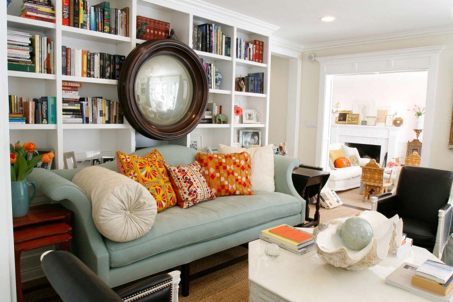 Книжный шкаф за диваном в гостиной