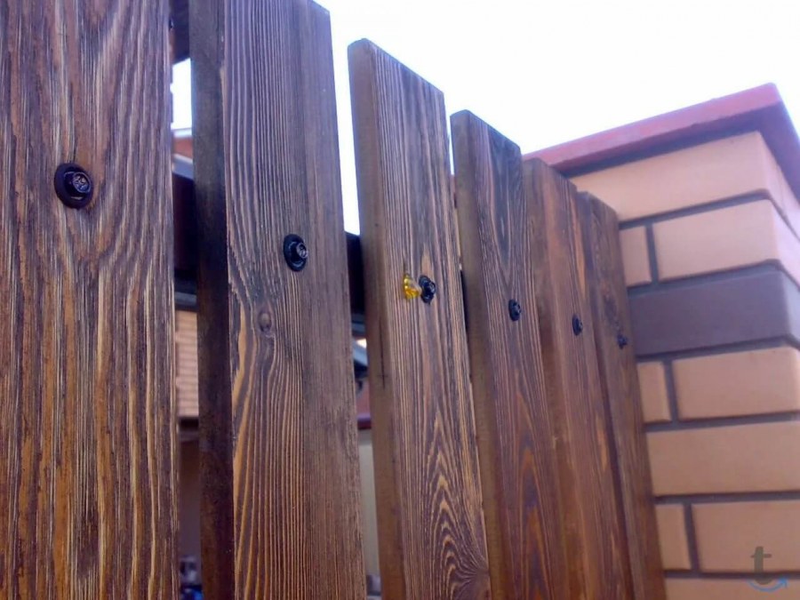 Сплошной деревянный забор на металлических Столбах