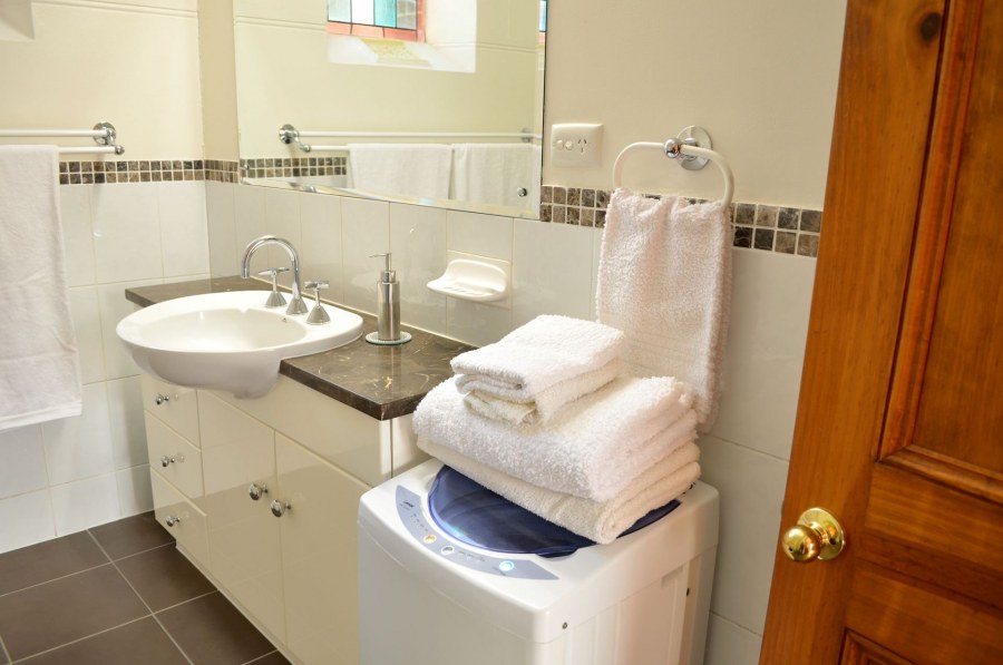 Машинка с вертикальной загрузкой в ванной