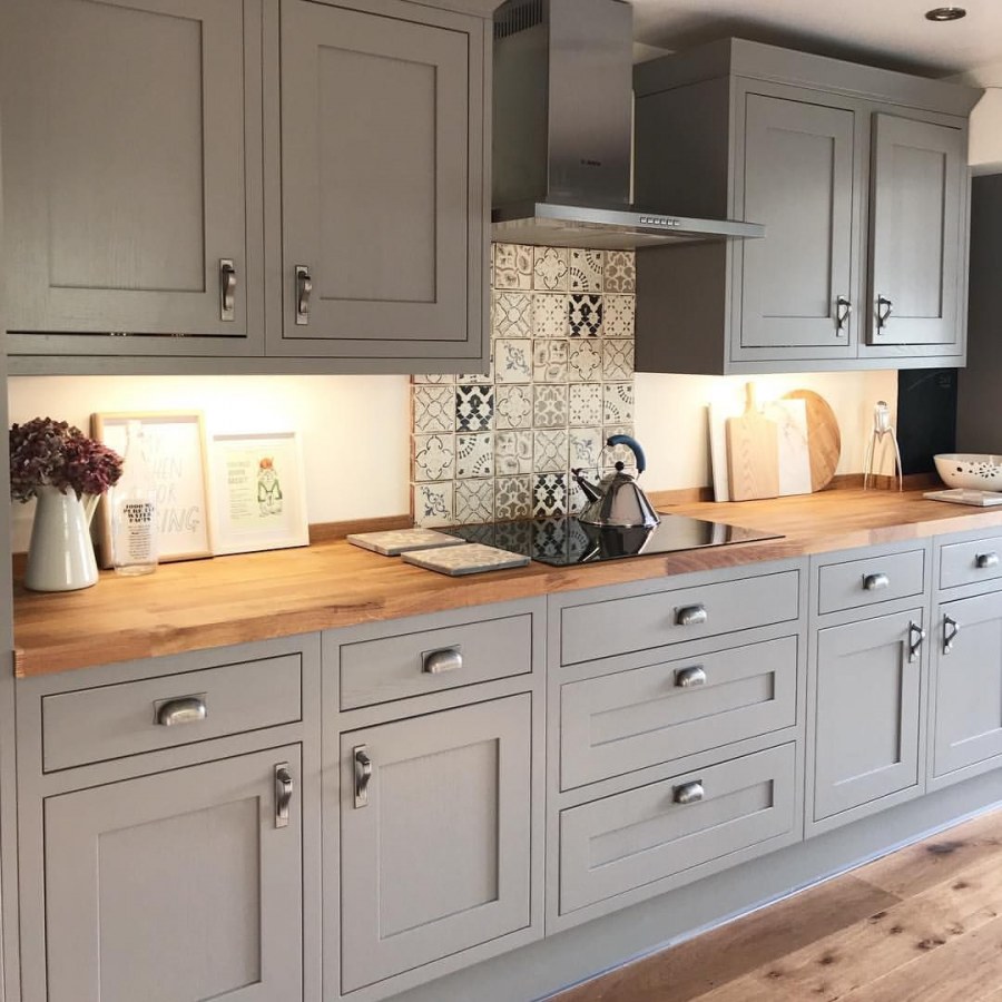Серый кухонный гарнитур с деревянной столешницей в интерьере фото